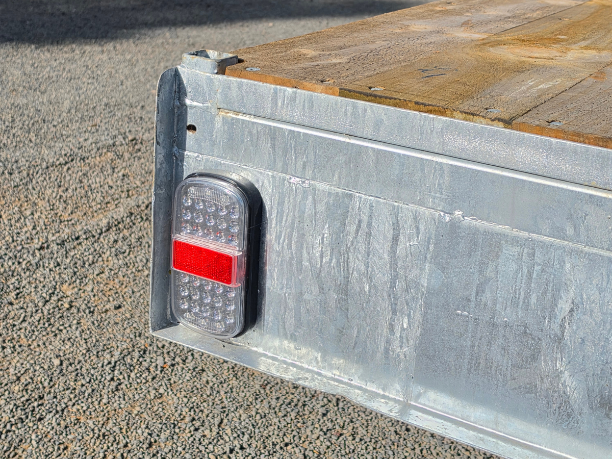 Rear corner of galvanised flat deck trailer with LED tail light and timber deck