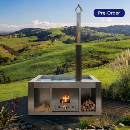 Oasis Retreat stainless steel wood-fired hot tub with integrated stove and chimney on a deck in New Zealand.